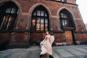 uma noiva dentro uma Casamento vestir com grandes cabelo dentro a velho Cidade do Breslávia. Casamento foto tiro dentro a Centro do a antigo cidade dentro polônia.wroclaw, Polônia