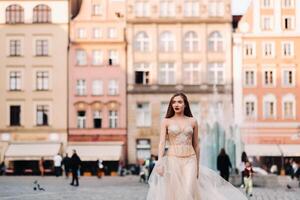 uma noiva dentro uma Casamento vestir com grandes cabelo dentro a velho Cidade do Breslávia. Casamento foto tiro dentro a Centro do a antigo cidade dentro polônia.wroclaw, Polônia