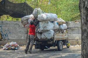 uma Carniceiro quem cargas lixo para dentro uma carrinho, Indonésia, 2 novembro 2023. foto