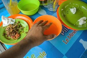 uma tigela preenchidas com limpar \ limpo água para lavando mãos dentro uma tradicional restaurante em a ilha do madura com alguns sobras Comida por aí isto, Indonésia, 17 novembro 2023. foto