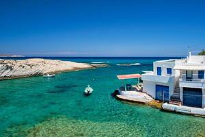 Grécia ilha Milos. pequeno Porto com pescaria barcos dentro água, branqueado casa. Mitakas Vila foto