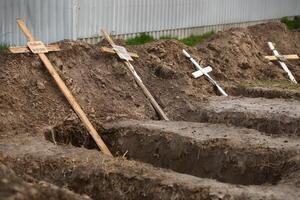 bucha, Ucrânia - abril 12, 2022 esvaziar sepulturas do a morto de a russo exército civis, enterrado de seus vizinhos dentro casa quintal, depois de exumação do seus corpos foto