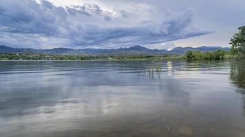 dramático crepúsculo céu e nuvens sobre rochoso montanhas e lago dentro norte Colorado foto