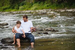 pai ensino filho quão para peixe voador dentro rio foto