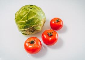 cubagem e tomates em branco fundo. orgânico Comida conceito. fique saudável. fresco produtos consumindo. foto