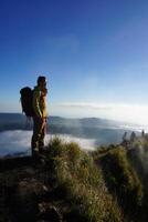 acima nuvem nove, montar batur pico, ásia homem trekker debaixo azul céu e nuvem mar foto