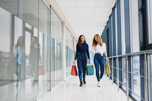 dois amigas em compras andar em compras Centro com bolsas foto