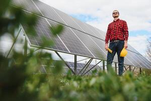 solar painéis e azul céu.homem em pé perto solar painéis. solar painel produz verde, ambientalmente amigáveis energia a partir de a Sol. foto