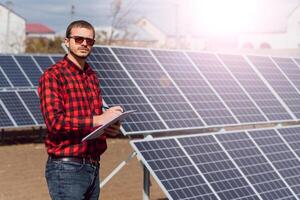 solar painéis e azul céu.homem em pé perto solar painéis. solar painel produz verde, ambientalmente amigáveis energia a partir de a Sol. foto