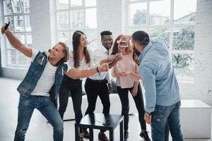 deixe esse álcool escorrer. jovens amigos alegres se divertindo e bebendo no interior branco foto