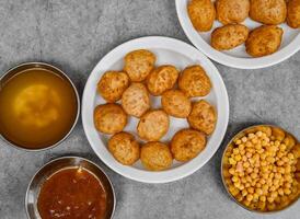 pani puri ou gol gappay com dahi, querido, picante água, molho picante e molhoservido prato isolado em fundo topo Visão do indiano especiarias Comida foto