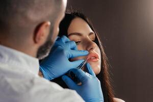 a médico cosmetologista faz lábio aumento procedimento do uma lindo mulher dentro uma beleza salão.cosmetologia pele Cuidado. Alto qualidade foto