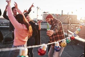 cantando músicas favoritas no telhado com amigos e álcool nas mãos foto