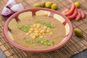 fol com grão de bico, tomate, e azeitonas servido dentro prato isolado em mesa lado Visão do árabe Comida foto