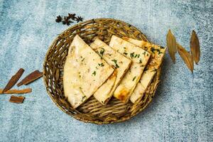 especial Masala kulcha naan servido dentro uma cesta isolado em cinzento fundo topo Visão do Bangladesh Comida foto