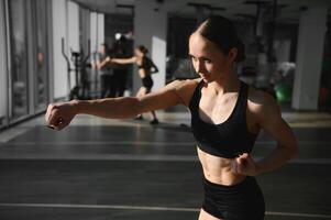 boxe mulher durante exercício-cinza fundo às Academia foto