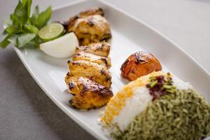 Jujeh frango tikka boti kabab com arroz e salada servido dentro prato isolado em cinzento fundo topo Visão do árabe Comida foto