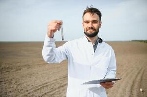 solo teste. agronomia especialista levando solo amostra para fertilidade análise. mãos dentro luvas fechar acima. de Meio Ambiente proteção, orgânico solo certificação, campo trabalhar, pesquisar. foto