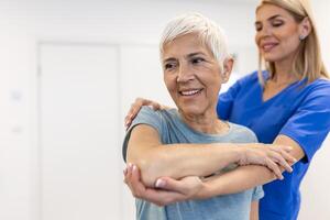 profissional terapeutas é alongamento músculos, Senior paciente com anormal muscular sintomas, fisica reabilitação terapias e tratamento do fisiológico desordens de fisioterapeutas conceito. foto