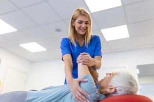 médico ou fisioterapeuta ajuda para curar uma Senior mulher voltar. e dar adendo dentro a reabilitação Centro. conceito do fisica reabilitação. foto