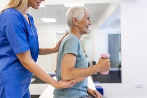 profissional fisioterapeuta trabalhando em específico músculo grupos e costas dor com Senior fêmea. mulher recuperando a partir de suave ferida. trauma prevenção terapia ou reabilitação às clínica foto