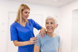 mulher médico osteopata dentro médico uniforme fixação Senior mulher pacientes ombro e costas juntas dentro manual terapia clínica durante Visita. profissional osteopata durante trabalhos com paciente conceito foto