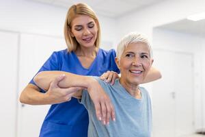 médico ou fisioterapeuta trabalhando examinando tratando ferido braço do Senior paciente, alongamento e exercício, fazendo a reabilitação terapia dor dentro clínica. foto