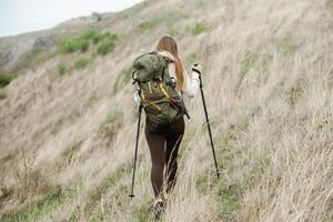 jovem mulher com mochila caminhada dentro a montanhas. caminhada conceito. caminhada falésias. viagem, viajante. foto