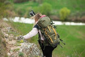 jovem mulher com mochila caminhada dentro a montanhas. caminhada conceito. caminhada falésias. viagem, viajante. foto