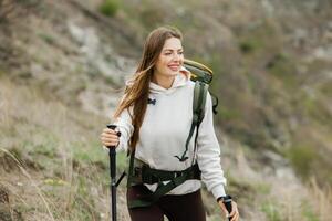 jovem mulher com mochila caminhada dentro a montanhas. caminhada conceito. caminhada falésias. viagem, viajante. foto