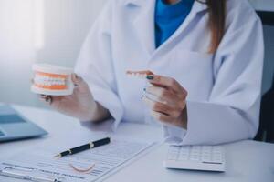 dentistas estão discutindo problemas dentários na imagem de raio-x do relatório na tela do laptop para os pacientes. foto