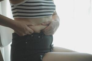 mulheres corpo gordo barriga. obeso mulher mão segurando excessivo barriga gordo. dieta estilo de vida conceito para reduzir barriga e forma acima saudável estômago músculo. foto