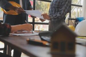 uma equipe do construção engenheiros fala para gerentes e construção trabalhadores às a construção local. qualidade inspeção, trabalhos plano, casa e industrial construção Projeto projeto foto