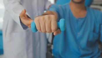 fisioterapeuta homem dando exercício com haltere tratamento sobre braço e ombro do atleta masculino paciente fisica terapia conceito foto