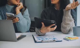 co conferência de trabalho, reunião da equipe de negócios presente, colegas investidores discutindo os dados do gráfico financeiro do novo plano na mesa do escritório com laptop e tablet digital, finanças, contabilidade, investimento. foto