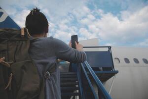 feliz atraente ásia mulher viajante com mochila às a moderno aeroporto terminal, cópia de espaço, turista viagem viagem conceito foto