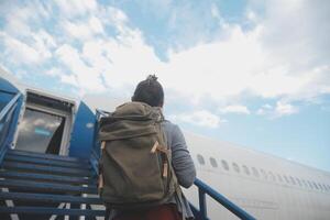 feliz atraente ásia mulher viajante com mochila às a moderno aeroporto terminal, cópia de espaço, turista viagem viagem conceito foto