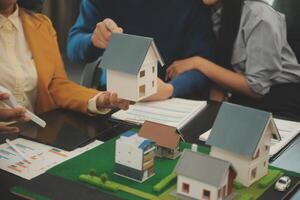 equipe do arquiteturas e empresários discutindo e debate em chão plano modificação para real Estado investimento e habitação desenvolvimento projeto foto