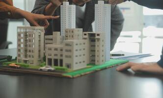 equipe do arquiteturas e empresários discutindo e debate em chão plano modificação para real Estado investimento e habitação desenvolvimento projeto foto