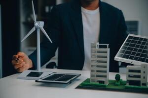 dois jovem engenheiros perícia dentro solar célula instalação Encontros e discussão dentro a trabalho. planejamento para instalar solar fotovoltaico painéis em cobertura topo dentro a escritório quarto com fábrica construção plano. foto