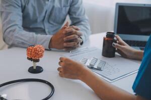 médico explicando cérebro funções para paciente em modelo dentro escritório. foto