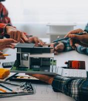 engenheiro pessoas encontro trabalhando e apontando às uma desenhos dentro escritório para discutindo. Engenharia Ferramentas e construção conceito. foto