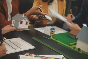 equipe do arquiteturas e empresários discutindo e debate em chão plano modificação para real Estado investimento e habitação desenvolvimento projeto foto