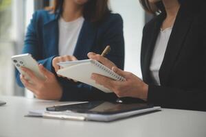 empresário asiático empresário e empresária discutindo novo projeto de negócios em tablet em reunião moderna no escritório moderno, conceito casual de negócios asiáticos. foto