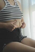 mulheres corpo gordo barriga. obeso mulher mão segurando excessivo barriga gordo. dieta estilo de vida conceito para reduzir barriga e forma acima saudável estômago músculo. foto