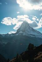 matterhorn montanha com turista jogando pára-quedas em azul céu dentro luz do dia às Suíça foto