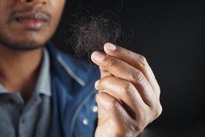 homem segura seu cabelo de lista de perto foto