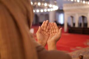 muçulmano jovem mulher dentro hijab é Rezar dentro mesquita. foto