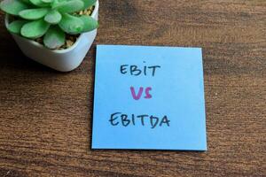 conceito do ebit vs ebitda escrever em pegajoso notas isolado em de madeira mesa. foto