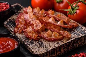 delicioso fresco frito bacon com sal e especiarias em uma Sombrio fundo foto